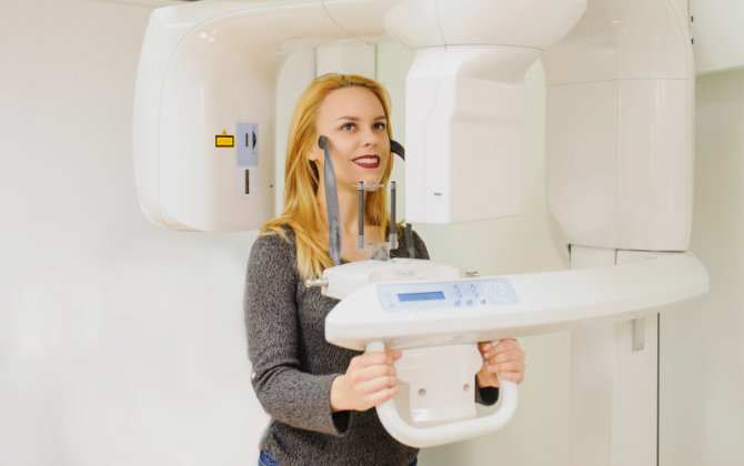 A woman standing in front of a mri machine.