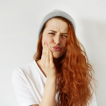 redhead girl suffers from toothache