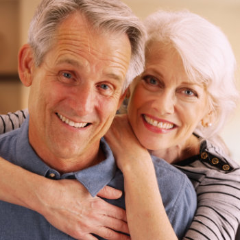 cheerful elderly couple embrace each other