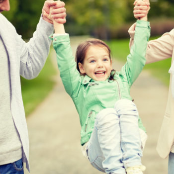 child playing outside with parents